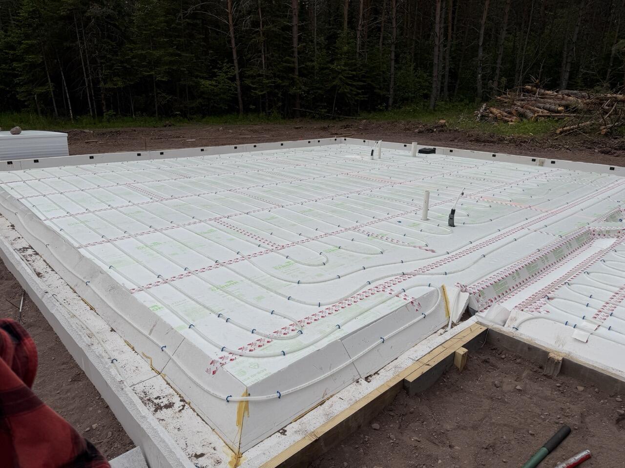 Wide angle view of an insulated floor assembly with radiant tubing before the concrete pour