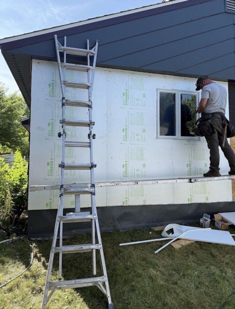 Installer setting a window over Eco Carbon continuous exterior foam insulation