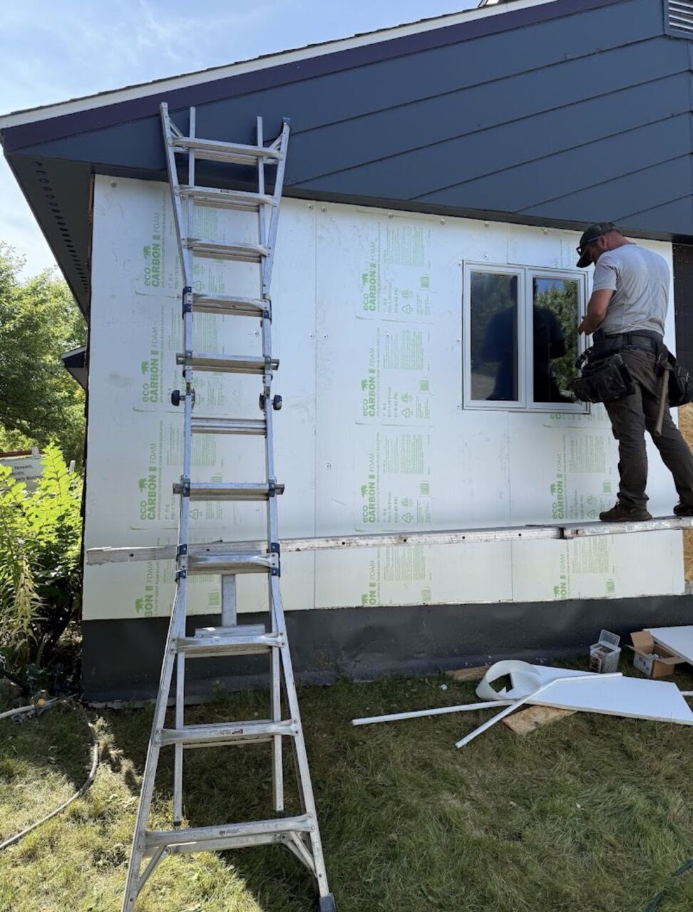 Installer setting a window over Eco Carbon continuous exterior foam insulation